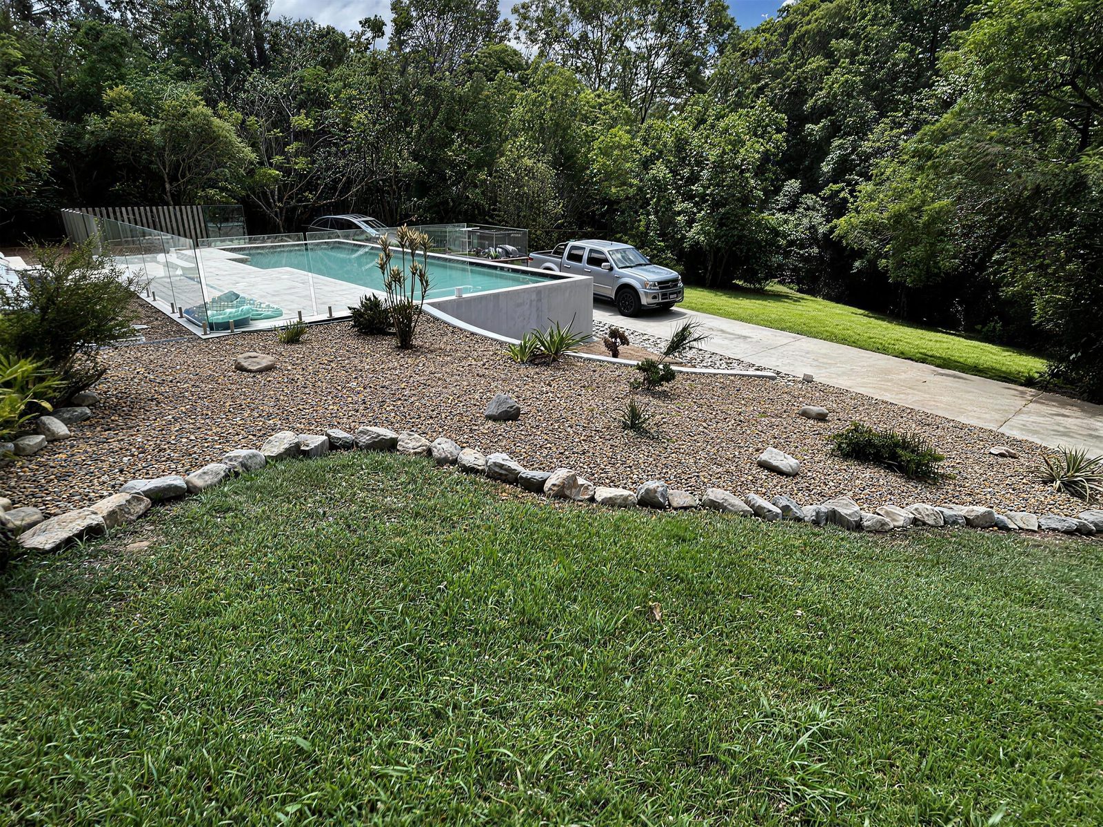 New lawn and rock-edged garden bed by the pool