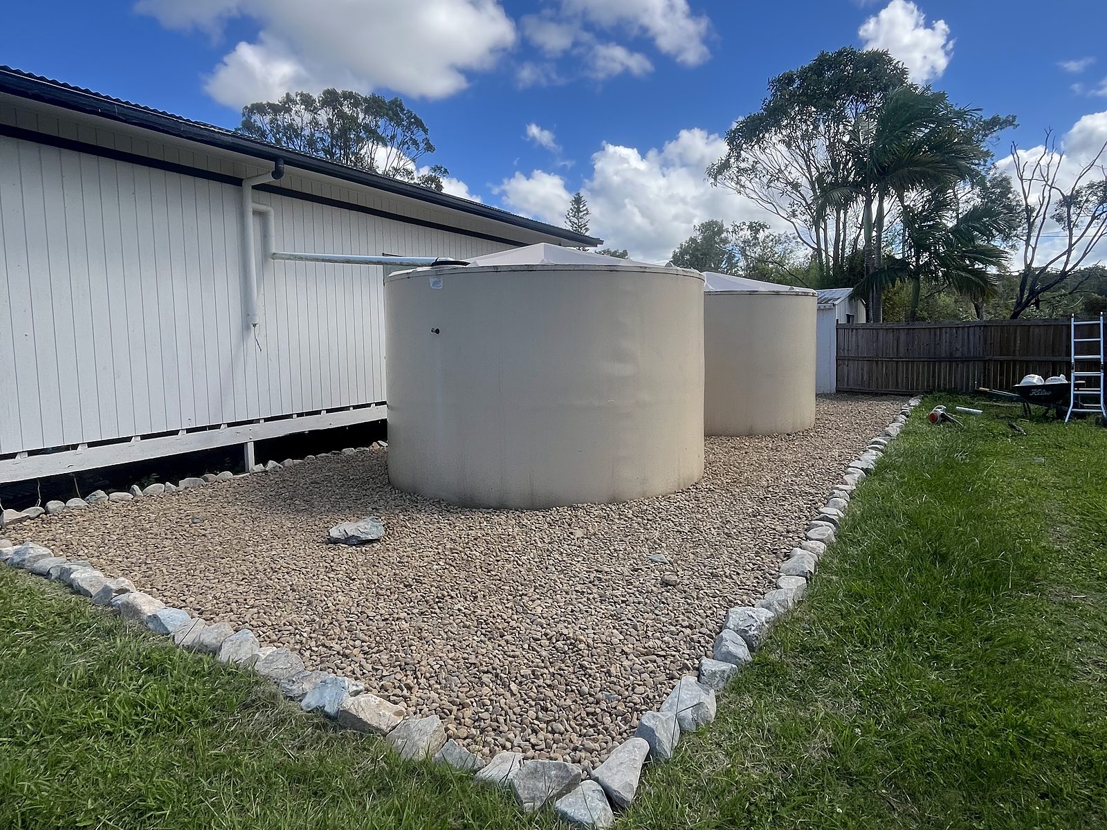 Water tanks on a new gravel pad with rock edging