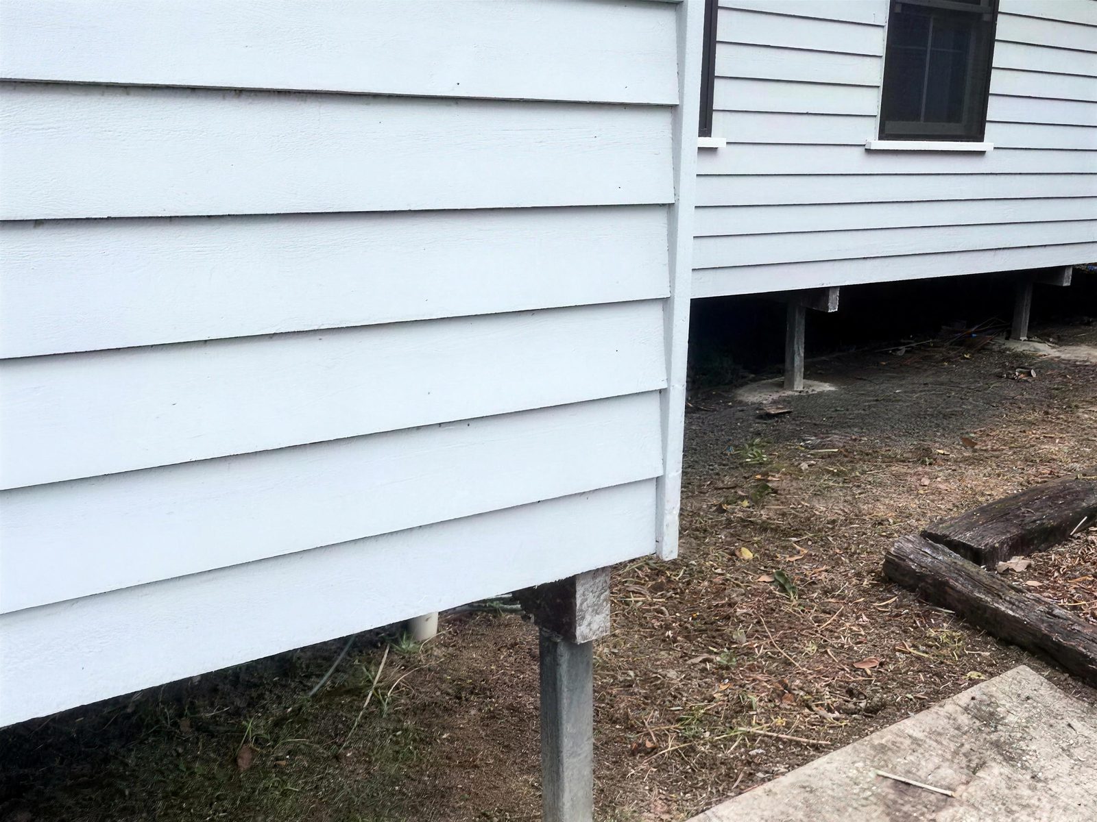 Clean weatherboards and cleared ground beside the house